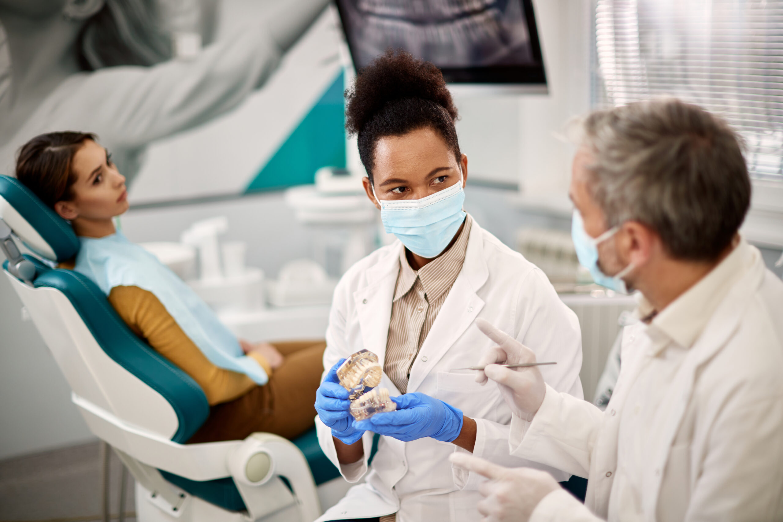 Two dentists discussing their patient's dental health in the office.