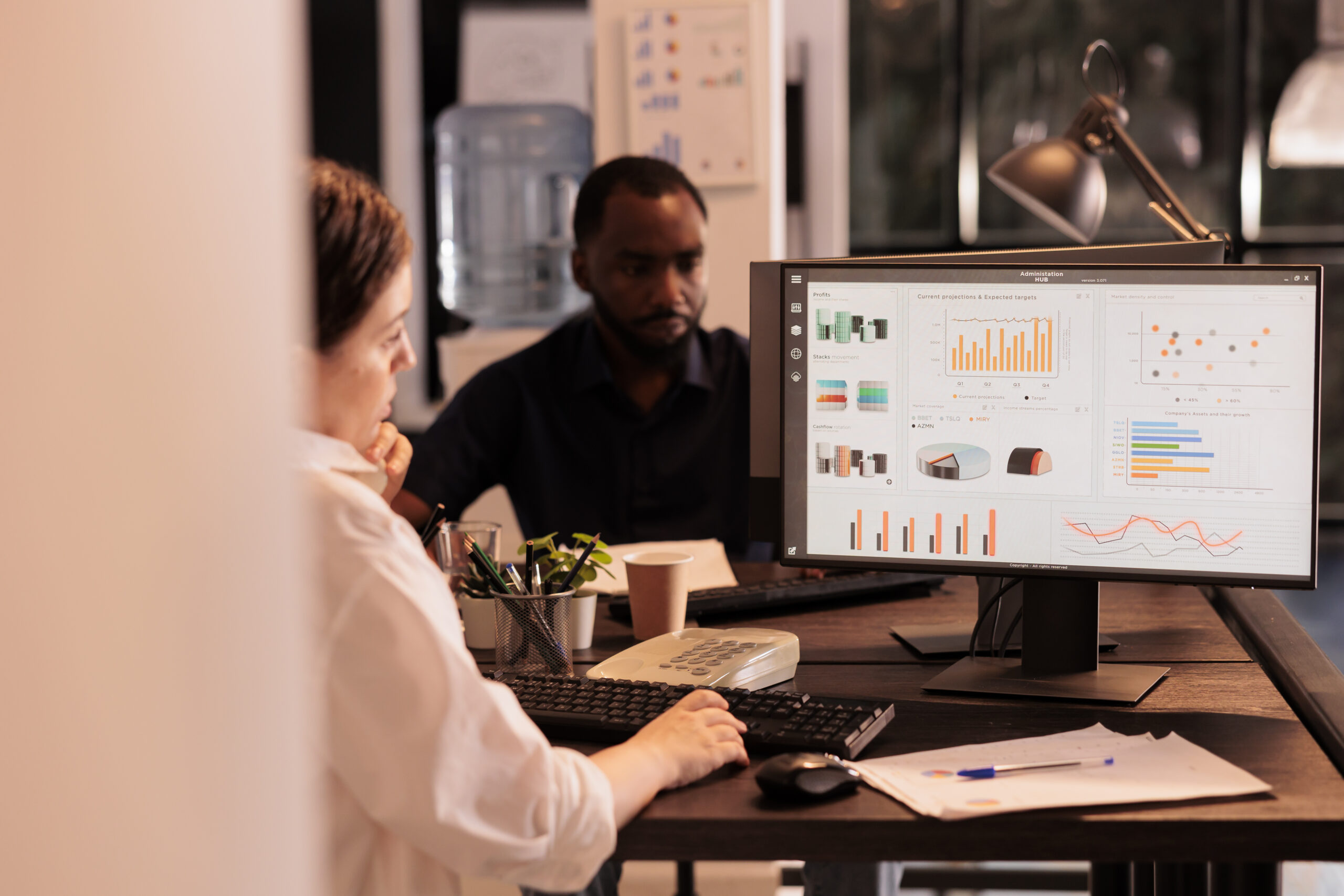 An employee analyzing a company report displayed on a computer screen.